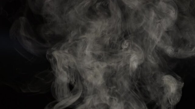 White smoke on a black background in slow motion