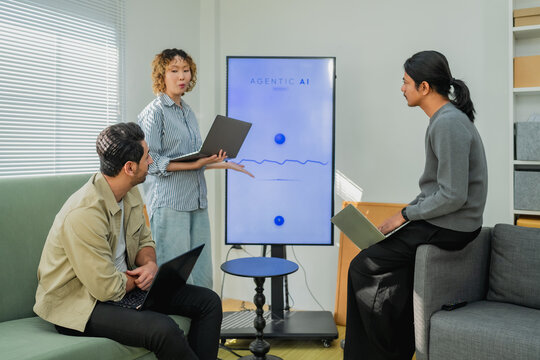 Diverse business team in agile workspace analyzing agentic AI software presentation on screen for digital marketing tech startup creative collaboration strategy hybrid office background