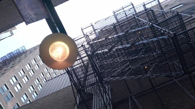An upward view of metal fire escape structures on a Chicago building. The scene emphasizes urban architecture and industrial design.