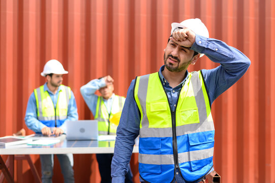 logistic staff workers tired from hard work. container yard worker wearing reflective vest and white helmet. Cargo Ship Import Export Factory Logistic.
