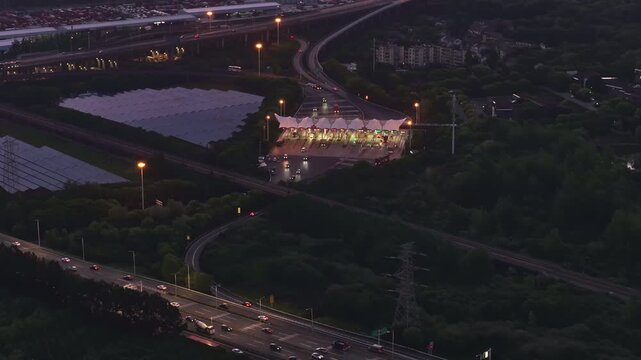 Aerial photography of a photovoltaic power station near an urban transportation hub at sunset