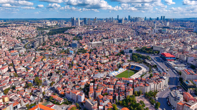 4K aerial drone view of Kasimpasa Stadium within dense Istanbul cityscape and Golden Horn waterway, Beyoglu, Istanbul, Turkey