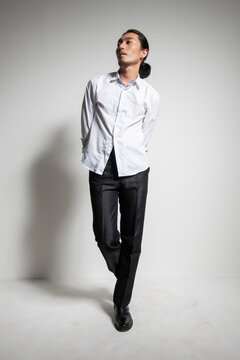Studio portrait of an Asian man wearing a white shirt.