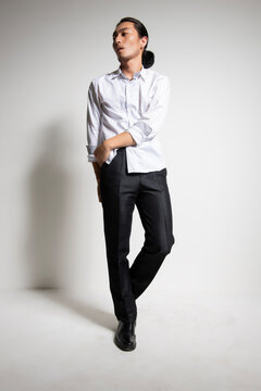 Studio portrait of an Asian man wearing a white shirt.