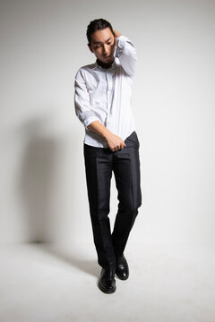 Studio portrait of an Asian man wearing a white shirt.