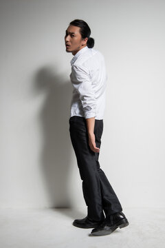 Studio portrait of an Asian man wearing a white shirt.