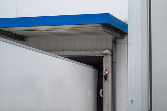 Loading dock operations take place at a warehouse with a truck waiting to unload goods in the early morning hours