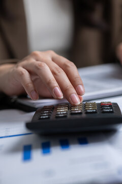 Calculator hand finance document business accounting report chart finger office, close up of person pressing calculator on financial paperwork for budget planning and analysis Vertical