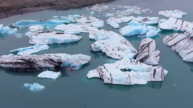 Stunning aerial perspective of Jokulsarlon glacier lagoon in Iceland. Massive icebergs with volcanic ash floating on the cold water