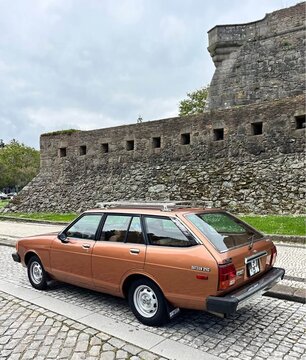 Brown datsun 210 station wagon parked near a stone wall in Porto