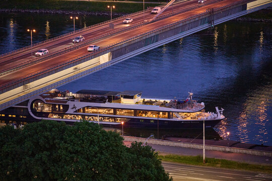 Avalon Passion river cruise ship docked on the Danube River under the Most SNP bridge at night, Bratislava, Slovakia, Central Europe.