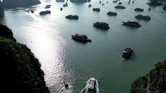 Serene Maritime. Drone view Tranquil Halong Bay Dotted With Anchored Vessels And Limestone Islands