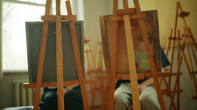 Wooden easels arranged inside a bright art classroom, representing creative education, artistic workshops, and learning spaces dedicated to visual arts and design