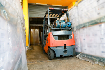 Back view Hydraulic forklift powered by an LPG fueled engine is parked in a warehouse filled with boxes of goods for logistics transportation within an industrial factory. © ฺฺฺBoonterm