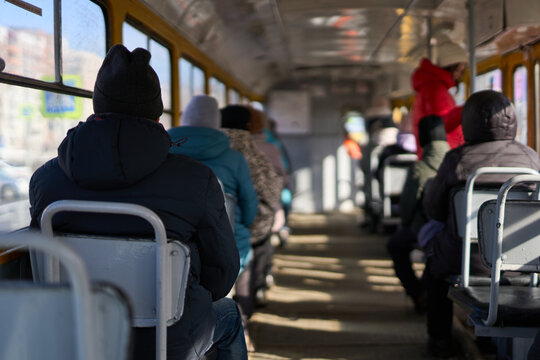Barnaul, Siberia, Altai region, Russia - 25 March 2026: Commuters Seated Facing Forward On Crowded Daytime City Bus Interior With Insulated Winter Coats Hats Sunlight Streaming Through Side
