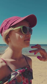 applying sunscreen on child face on the beach. skin protection from sunburn