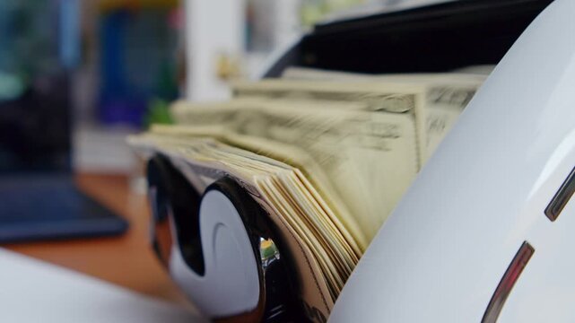 A cash counting machine quickly sorts and stacks money in a vibrant office filled with color and energy, showcasing the efficiency of modern financial processes