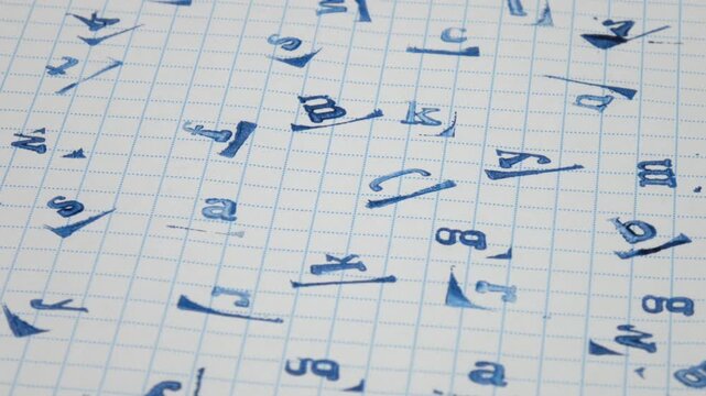 Blue various prints of the letters of the English alphabet on checkered paper, abstract background