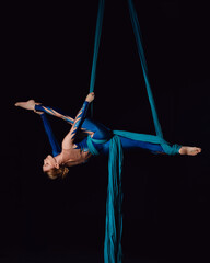 Young female gymnast doing split on aerial silks © Inna