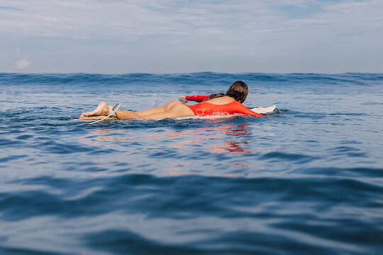 Surfer girl on surfboard. Attractive woman during surfing