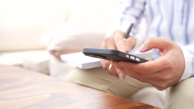 Business professional using smartphone to review information, manage tasks and take notes. Mobile productivity, workflow management, digital communication and planning concept with copy space.