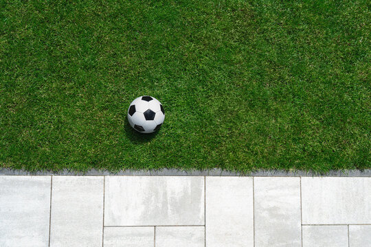 green grass texture - well-groomed turf with soccer ball in the garden