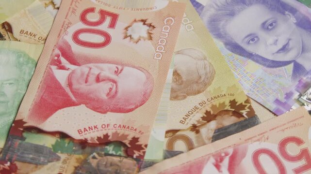 Vibrant banknotes of Canada are beautifully arranged, revealing their rich colors and unique portraits. Each detail tells a story of culture and history