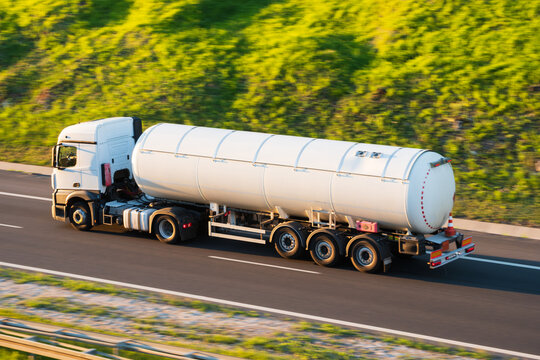 White road tanker fuel truck hauling liquid cargo on highway, fast transportation delivery concept