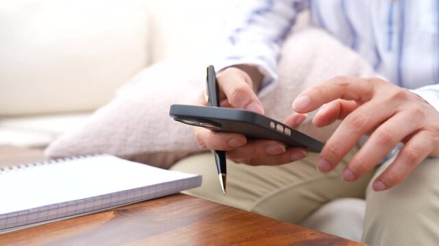 Using smartphone to review information and record notes for planning, task management and business organization. Mobile productivity, digital communication and workflow management concept.