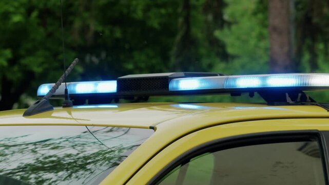 Close up view of a flashing blue emergency light bar mounted on a vehicle