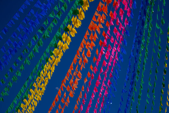 C&eacute;u azul preenchido por dezenas de bandeirinhas coloridas de Festa Junina