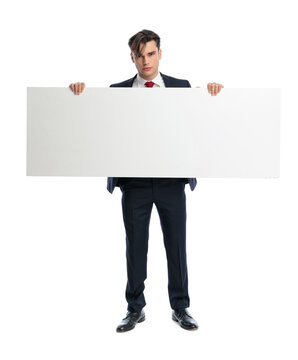 Serious man holding blank board