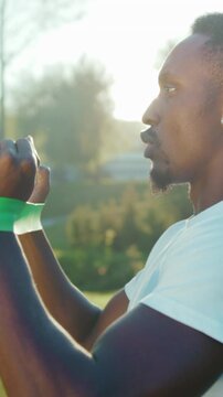 Sunrise outdoor workout, Focused man engages in vigorous resistance band workout during early morning in park