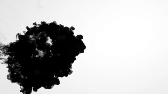 Video of intense black ink injected into clear water on a white background, swirling into dense, elegant smoke clouds perfect for backgrounds, transitions, text reveals, or luma matttes