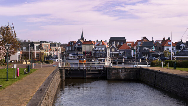 View of Lemmer city center with a canal lock in the foreground, Netherlands. A typical Dutch waterscape combining urban life and maritime infrastructure.