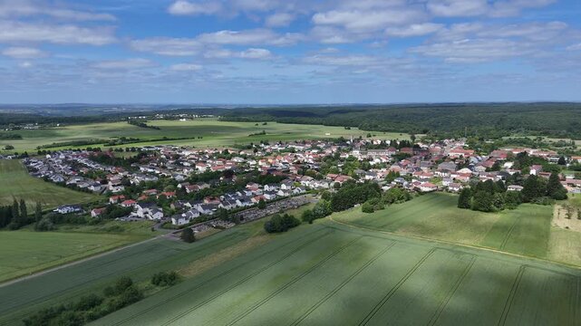 vue a&eacute;rienne panoramique du village d'Haucourt-Moulaine, en Meurthe-et-Moselle, Lorraine. vue d'ensemble des habitations et des b&acirc;timents dans un paysage rural entre champs cultures et for&ecirc;ts.