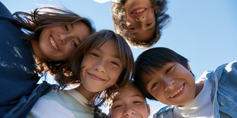 Obraz premium Joyful circle of children smiling in a selfie under a clear blue sky for banner background and website hero image showcasing friendship and outdoor play
