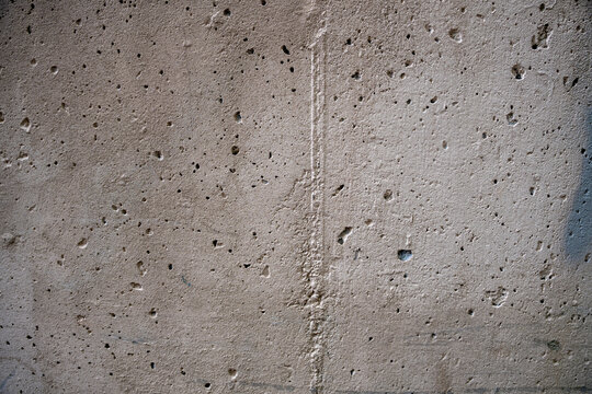 Rough concrete wall texture background with pitted surface and air bubbles