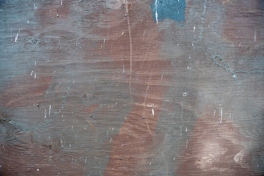 Distressed multi-colored wood texture background with brown and grey paint stains