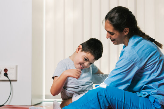 Physiotherapist assisting child with cerebral palsy during therapy session