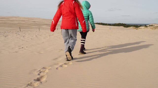 Little girl on the white sand dunes of Leba