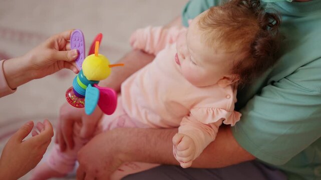 Close up of a caregiver lifting and supporting an infant during mobility exercises