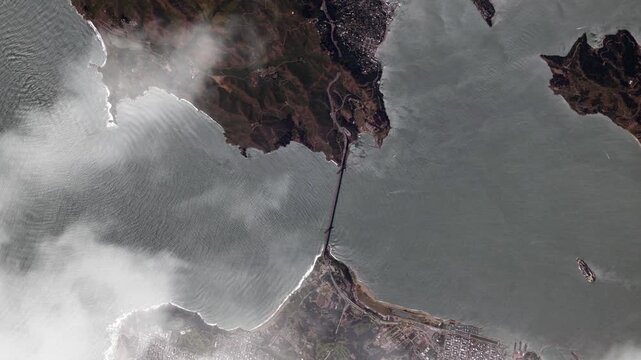 Rotating aerial view of Golden Gate Bridge and San Francisco Bay with passing clouds satellite view from space based on Nasa imagery