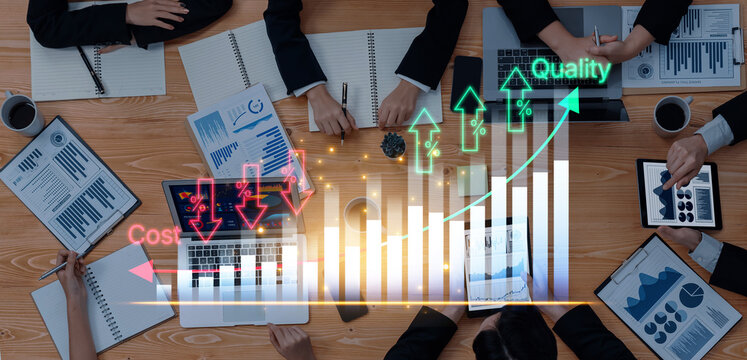 Collaborative Business Meeting with Charts and Graphs Analyzing Cost, Quality, and Growth on Digital Devices and Documents on Wooden Desk. Bitwise.