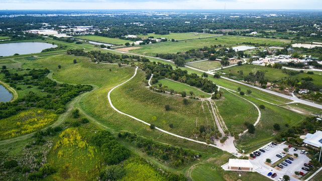Celery Fields features a prominent hill&mdash;a landmark in Sarasota, Florida. It rises boldly over lush emerald wetlands, a shimmering lake, and winding trails. Soft, evening light diffuses over the vibran