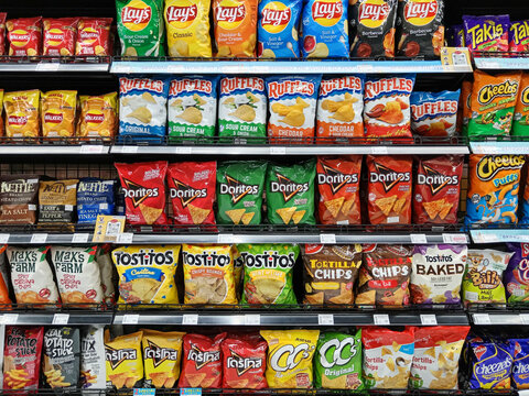 Variety of Ultra Processed Junk Food Potato Chips on Display at Grocery Store
