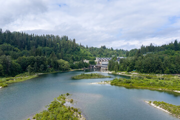 Obraz premium Hydroelectric Dam and River Surrounded by Lush Evergreen Forest Landscape Near Mission, BC, Canada