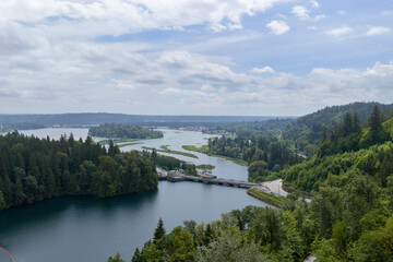 Fototapeta premium Aerial View of River and Forested Landscape With Bridge Near Mission, BC, Canada on Overcast Day