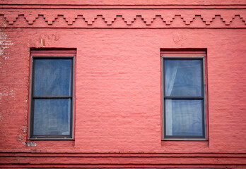 Fototapeta premium Faded Red Old Building with Brick Facade and Windows.