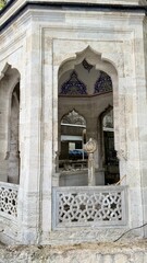 Fototapeta premium Ancient marble ablution pavilion with carved stone lattice and blue tiles at Eyup Sultan Mosque courtyard in Istanbul, Turkey. Old Ottoman empire buildings exterior architecture design details.